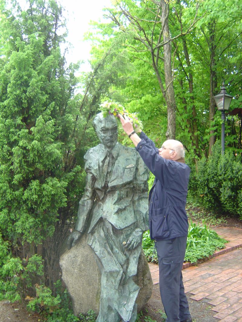 Hasse Eson avslutar arrangemanget Första frukost i Fridegårdsparken 2007 genom att sätta en blomsterkrans på Jans huvud.